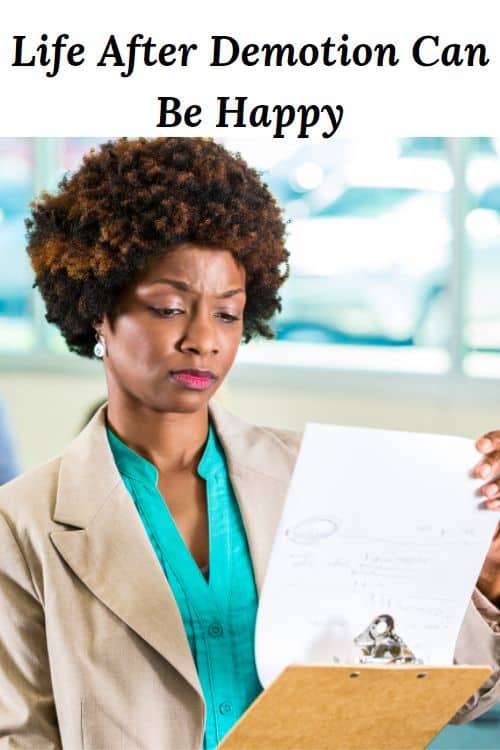 Serious African American woman looking at paperwork and the words "Life After Demotion Can Be Happy"